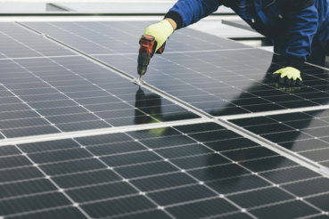 a-person-working-on-a-solar-panel.jpg a person working on a solar panel